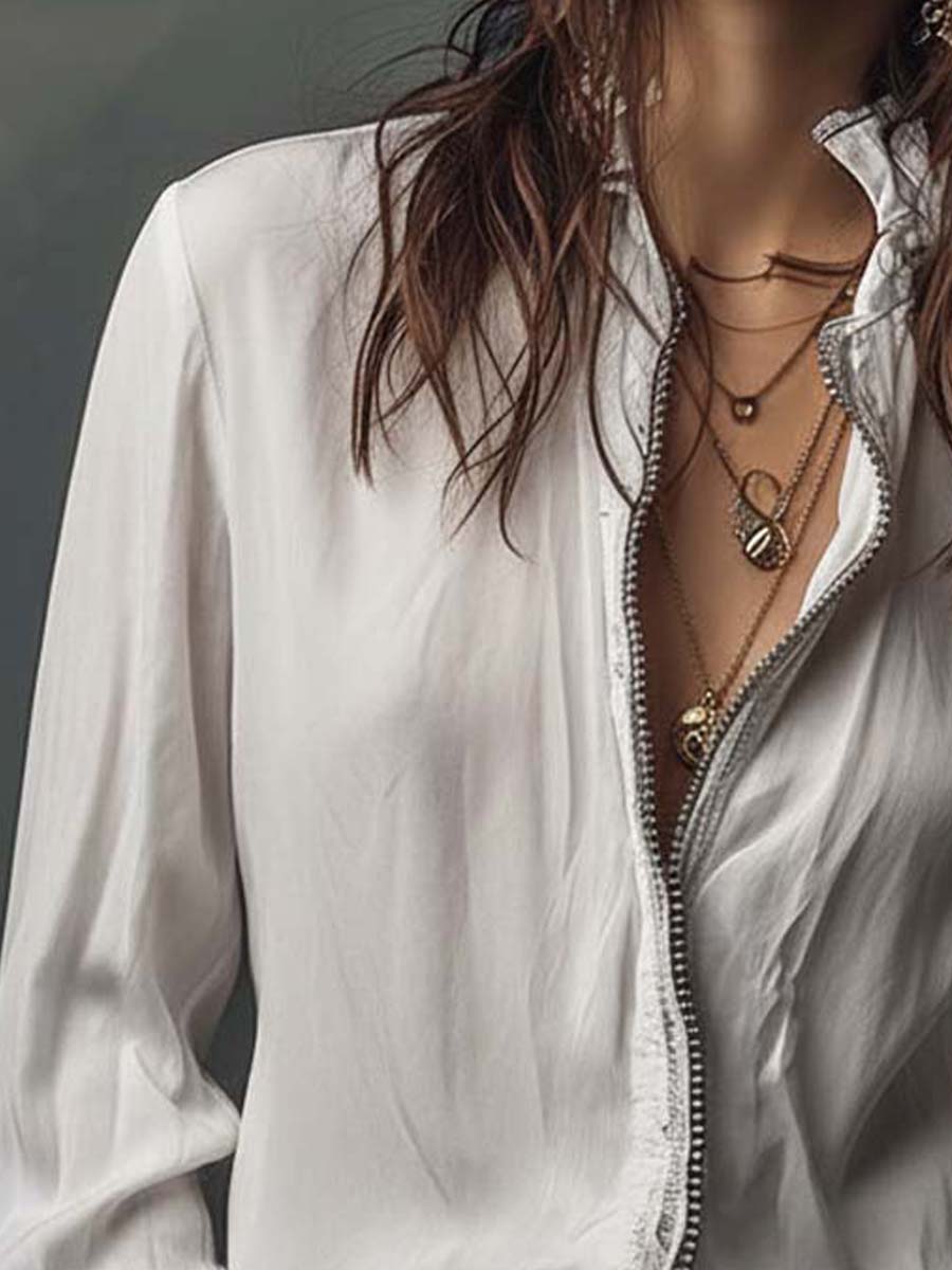 Blusa blanca con cremallera frontal y puños con volantes