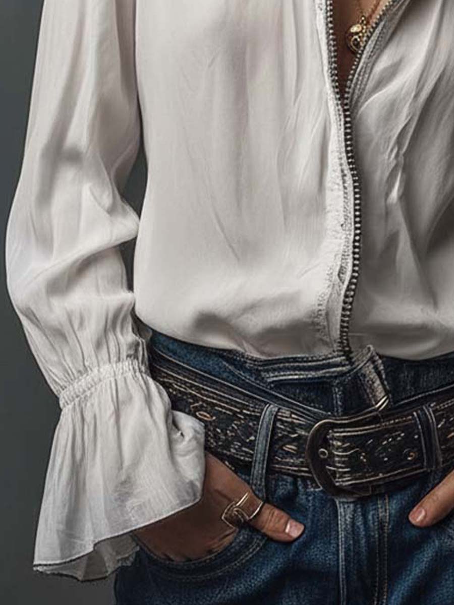 Blusa blanca con cremallera frontal y puños con volantes