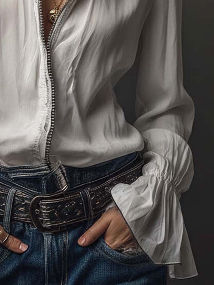 Blusa blanca con cremallera frontal y puños con volantes