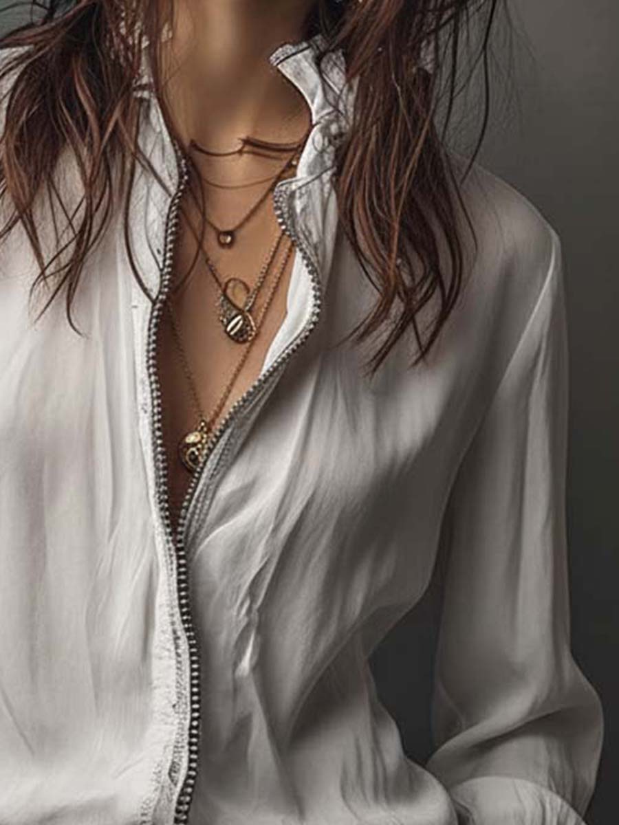 Blusa blanca con cremallera frontal y puños con volantes