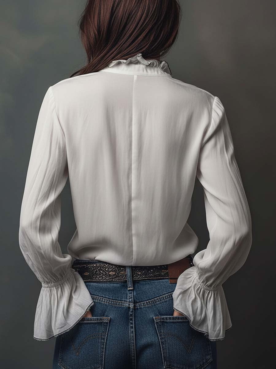 Blusa blanca con cremallera frontal y puños con volantes